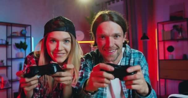 Close up portrait of good-looking happy gambling active young couple which enjoying videogames and celebrating victory with high five at home in the evening — Stock Video