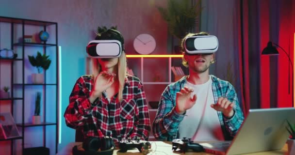 Portrét dobře vypadajícího sebevědomého zkušeného mladého páru, který se pohybuje rukama na virtuální obrazovce pomocí speciálních 3D brýlí pro práci doma večer, koncept vzdálené práce — Stock video