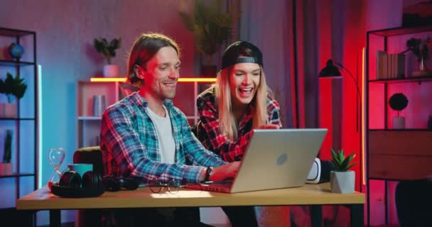Familienfreizeitkonzept, bei dem entzückend glücklich lächelndes liebevolles junges Paar am Abend die gemeinsame Zeit zu Hause am Computer verbringt — Stockvideo