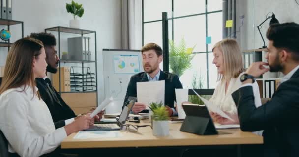 Üzleti koncepció, ahol jóképű, pozitív, magabiztos szakállas főnök beszél a multiracionális férfi és női vállalati munkatársaival az irodai eligazítás alatt — Stock videók