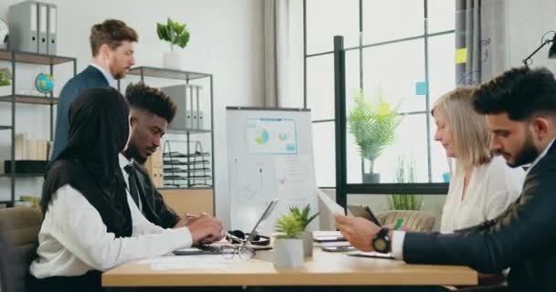 Acelerando el rodaje de la cámara en el enojado gerente principal barbudo irritado que sacudía a sus asustados subordinados multirraciales confusos sobre los malos resultados del trabajo — Vídeo de stock