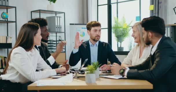 Conceito de colaboração empresarial em que empresários de raça mista bem-parecidos e bem sucedidos votam com as mãos no ar após o término da reunião conjunta e cumprimentam uns aos outros com aplausos — Vídeo de Stock