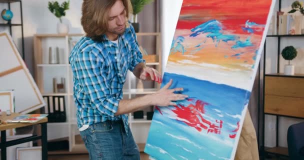 自宅のワークショップで手で絵に絵を適用する絵を作成し、現代の才能のある30歳の男性芸術家のように、芸術の概念 — ストック動画