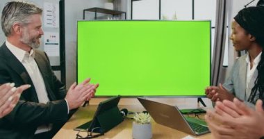Sevimli, kendine güvenen, nitelikli çeşitli iş adamları şirket ofisinde oturmuş yeşil krom ve modern teknoloji konseptiyle TV 'de başarılı bir sunumdan önce veya sonra el çırpıyorlar.