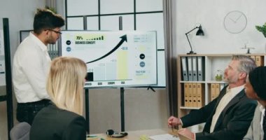 Çekici özgüvenin yüksek kalifiye melez iş arkadaşlarını motive ettiği iş ortaklığı konsepti konferans odasında iş stratejisini tartışıyor.
