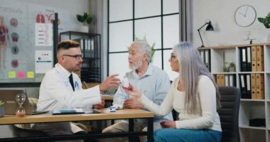 Doktor, resepsiyonda eşi olan yaşlı adamı muayene ediyor ve tedavi öneriyor..