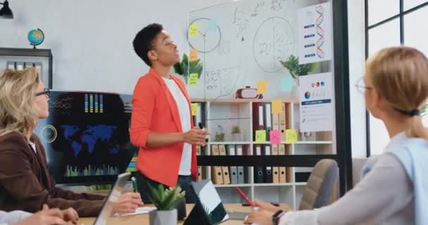 Dobře vypadající motivované kvalifikované různorodý ženský tým firemních spolupracovníků brainstorming společně přes společný obchodní koncept pomocí značek na skleněné zdi v kanceláři — Stock video