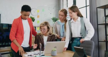 Çekici, kendine güvenen, yaratıcı, çok ırklı iş kadınlarının ofis odasındaki ortak bilgisayar projesiyle ilgili beyin fırtınası yaparken finansal belgelerle çalışmasını sağladı.