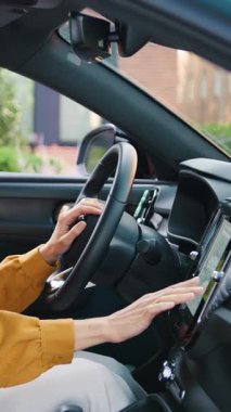 Güzel genç bir kadın modern bir arabanın içinde bir ekrana navigasyon kuruyor, bir yolculuğa hazırlanıyor. Teknoloji, seyahat, bağlantı ve çağdaş yaşam tarzı kavramı. Yavaş çekim