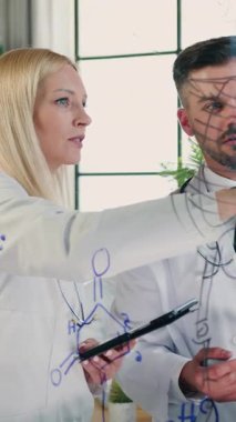 Çekici, zeki, başarılı sarışın ve sakallı erkek doktorların cam panonun yanında durduğu ve röntgen görüntülerini analiz ettiği klinik ofisinde çalışmak.