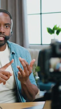 İyi görünümlü Afro-Amerikalı adam internet izleyicileri için video kaydediyor. Ev blogunda video kamera kullanıyor..