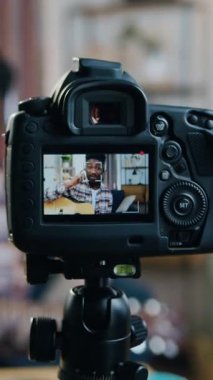 Genç Afrikalı Amerikalı erkek gitarist. Evde oturup uzaktan öğrenme konsepti olan çevrimiçi dinleyicilere gitar çalmayı öğretiyor.