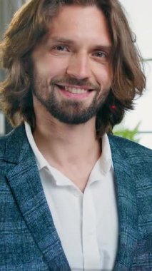 Çekici, olumlu, 35 yaşında, takım elbiseli bir menajerin portresi. Kameraya bakıyor, gülümsüyor ve baş parmağını kaldırıyor. Yavaş çekimde.