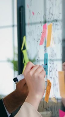 İyi görünümlü, yaratıcı, başarılı iş arkadaşlarının çalışma akışı konsepti cam duvarın yanında yeni iş projeleri için yeni fikirler üretiyor.