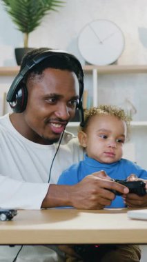 İyi huylu, neşeli, 30 yaşında, Afro-Amerikalı, kulaklık takmış bir baba. Küçük çocuğuyla evde kalıyor ve bilgisayar başında video oyunlarının keyfini çıkarıyor. Zaferi kutluyor.