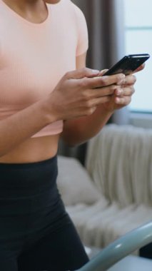 Güzel, tatmin olmuş, aktif, 30 yaşında Afro-Amerikan kadın, antrenman kıyafetleri içinde. Koşu parkurunda yürüyüş egzersizleri yapıyor ve keyifli telefon konuşmaları yapıyor. Aktif yaşam tarzı kavramı.