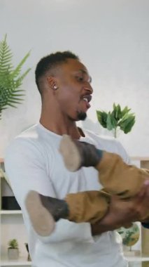 Yakışıklı, şefkatli, Afrikalı, Amerikalı bir baba. İki yaşındaki bebeğini kucağında tutuyor ve döndürüyor. Sanki rahat bir odada, ön tarafta uçuyormuş gibi.