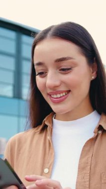 Akıllı telefon kullanan, mesaj yazan ya da ekranda numara çeviren kadınların yan görüntüsü. Açık havada..