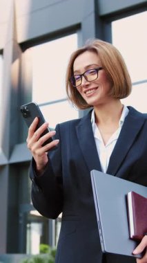 Ticari binalara karşı akıllı telefon kullanan işkadını ofis çalışanının portresi. Cep telefonuyla çalışan adam..