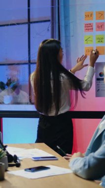 Çekici motivasyonlu, sorumluluk sahibi, çeşitli girişimcilerden oluşan bir ekibin, akşam ofiste fazla mesai yaparken ortak strateji üzerine beyin fırtınası yaptığı bir iş konsepti.