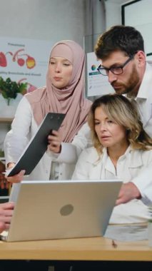 Saygıdeğer sakallı doktora tesettürlü güzel müslüman kadın doktor. Çok ırklı erkek ve kadın meslektaşlarıyla görüşürken önemli mali raporlara imza attırıyor.
