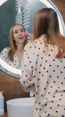 Happy woman looking in mirror touch healthy soft face skin after daily treatment. Skincare, professional care product cosmetics advertisement concept. Slow motion.