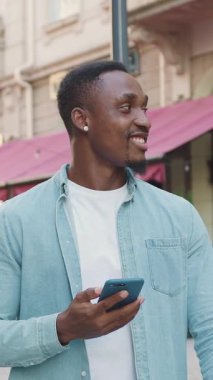 Sokağın aşağısında rahat bir kafeye gidip akıllı telefonunu kullanan, günlük giysiler içinde, 30 'lu yaşlarda, modern siyah tenli, çekici, çekici bir adama yaklaş.