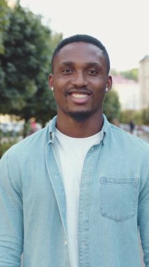 Yakışıklı, neşeli, mutlu 30 'lu yaşlarda, şık sakallı, şık giyinmiş, arka planda güzel yeşil bir sokakta poz veren, 4k.