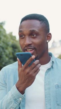 İyi huylu, 30 yaşında kaygısız Afrikalı Amerikalı şık sakallı, küçük yuvarlak küpeli, modayla gezen yeşil ağaçlarla sokakta yürürken video konferansının keyfini çıkaran biri.