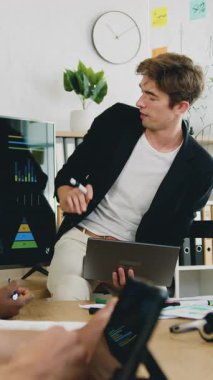 İş stratejisi konsepti, iş yerinde oturan ve akıllı iş ortağından dijital ekranda yapılan araştırmaların sonuçları hakkında rapor dinleyen çok kültürlü, sorumluluk sahibi üç erkek-iş arkadaşının...