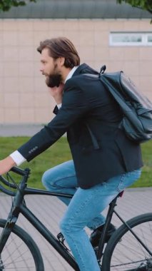 Sempatik, kendine güvenen, 30 yaşında, siyah ceketli, kotlu, bakımlı, modern bir iş adamı şehir kaldırımındaki bisikletle işe giderken seyyar bir konuşma yapıyor.