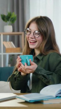 Hoş, neşeli, uzun saçlı, günlük giysiler içinde 25 yaşında bir kızın evinde güzel dekore edilmiş bir odada eğlenceli fotoğraflar ya da videolar izlediği bir eğlence konsepti.