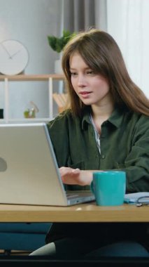 Çekici, neşeli, tedirgin, 25 yaşında, uzun saçlı bir kadının portresi. Bilgisayarın önünde oturmuş, ekranda süper bilgiler görmüş ve ellerini kaldırarak keyifli bir his yakalamış.