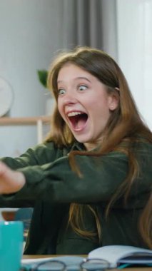 İnsani duygular ve başarı kavramı iyi görünümlü tedirgin genç bayan işçi ev bilgisayarının önünde oturuyor ve çalışmalarının iyi sonuçlarını monitörde görüyor ve komik bir tepkiyle seviniyor.