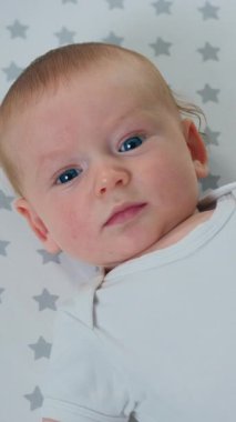 Anneler evde karın masajı yaparken beşikte yatan mutlu, güzel erkek bebeğe yaklaş. Bebek bakımı uzmanı. Yavaş çekim