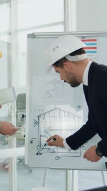 Mimarlar ya da inşaatçılardan oluşan çok yönlü profesyonel bir ekibin toplantı odasındaki yeni bina inşaatlarının ayrıntıları hakkında tavsiyede bulunduğu sanayi konsepti.