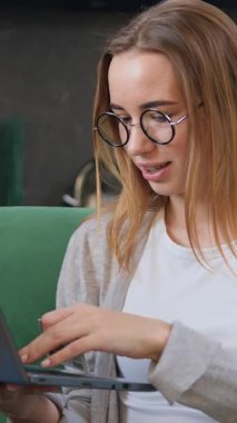 Evdeki kanepede oturan bir kız banka kartı ve dizüstü bilgisayarla online alışveriş yapıyor. Kadın müşteri para transferi yapıyor ya da internet üzerinden alışveriş yapıyor ve kredi kartı tutuyor. Yavaş çekim.