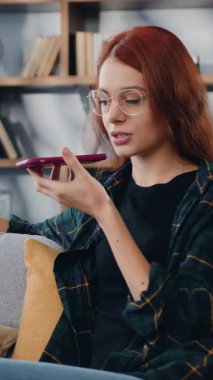 Neşeli bir kadının telefon araması portresi. Akıllı telefon tutan kız ses asistanı kullanarak arıyor. Teknoloji gelişmiş kullanıcı, sesli mesajlar, uzaktan iletişim konsepti. Yavaş çekim.