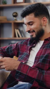 Gülümseyen İspanyol adam sosyal medya uygulamalarını kontrol ediyor oyun oynuyor, internetten alışveriş yapıyor, akıllı telefon siparişi veriyor. Yavaş çekim.