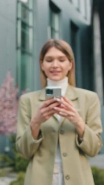 Portre, zaferi sokakta akıllı telefonla kutlayan kızı hayrete düşürdü. İş kadını ofisin arka planındaki cep telefonuna bakarak başarıdan zevk alıyor. Yavaş çekim.