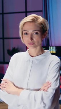 Güzel gülümseyen başarılı 35 yaşında kadın ofis müdürünün portresi. Kamerada şeffaf bir tablonun yanında duruyor. Kalem ve iş konseptiyle gerekli notları alıyor.