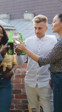 İyi huylu, modern, karma ırk gençliği erkek ve kız balkonda dikilip şehrin çatılarına bakıyor ve arkadaşlarının bira ve şarapla buluşmasını kutluyorlar.