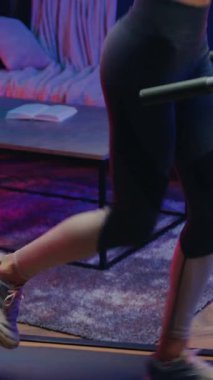 Tatmin edici, aktif, atletik, ince, 25 yaşında, antrenman elbiseli, kardiyo egzersizleri yapan, rahat bir gece aydınlatma odasında, kapat.