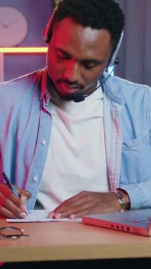 30 yaşında kulaklıklarla başarılı bir Afrikalı Amerikalı müşterilerle ya da iş arkadaşlarıyla internet üzerinden önemli notlar yazıyor.