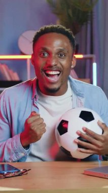 Yüksek moralli Afro-Amerikan erkek hayranı. Spor müsabakalarında zaferi kutluyorlar. Maçı evden izliyorlar.