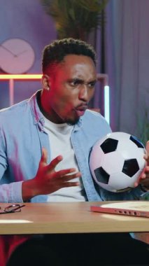 Güzel görünümlü, duygusal, neşeli, 30 yaşında, siyah tenli futbol fanatiği rahat bir odada bilgisayarın önünde oturuyor ve favori takımın zaferinden keyif alıyor.