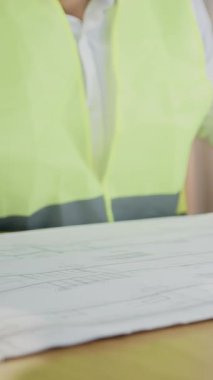 Tasarım ofisi iş akışı konsepti. Yüksek yetenekli, sakallı, koruyucu başlık ve yelek takan ve eskiz oluşturan kağıt üzerinde çalışan zeki bir mühendis.