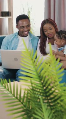 Çekici, olumlu, kaygısız genç adam ve kadın rasta ile küçük kızlarıyla birlikte yeni eve taşındıktan sonra karton kutuların arasında kanepede oturup bilgisayardaki ilginç programı gözden geçirirken eğleniyorlar.