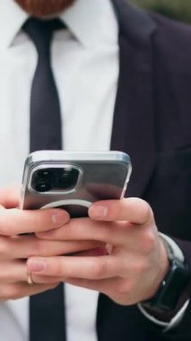 Kapatın. Dışarıda cep telefonu kullanan ciddi bir iş adamı. Sohbet etmek, internet üzerinden iş yapmak ve şehir merkezinde internet, iletişim ve ağ kurmak için gezmek. Yavaş çekim.