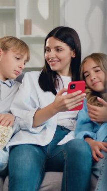 Dört kişilik mutlu bir aile akıllı telefon teknolojisi kullanmaktan keyif alır. Kanepede oturup akıllı telefon tutarak sohbet eden arkadaşlarınızı görmezden gelin. Yavaş çekim.